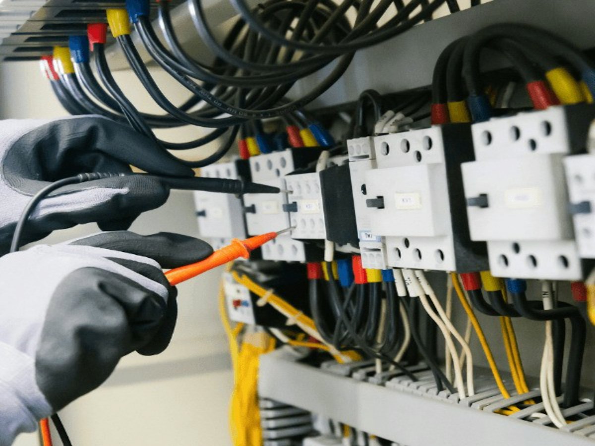 Engineer testing wiring inside a control panel